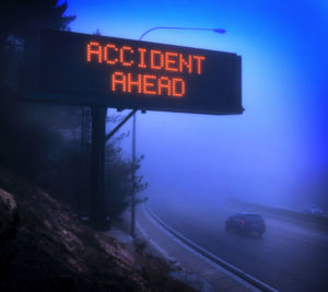 Highway road sign that says accident ahead surrounded by fog before a Bicycle Accident Lawyer West Lafayette IN is called to help