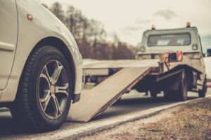 Car Accident Lawyer Frankfort, IN - Loading broken car on a tow truck on a roadside